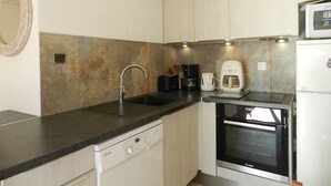 A compact kitchen with a dishwasher, a coffee maker, a toaster, and a microwave. - 2 Bedroom Apartment, Air Conditioning, Parking, Sleeps 4 (Bormes-les-Mimosas)