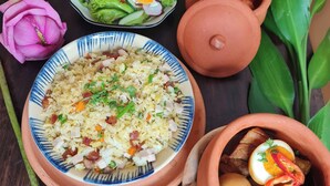 Una mesa con varios platos, incluyendo arroz, ensalada y una olla con huevos y verduras.