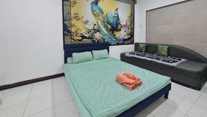 Un dormitorio con cama, sofá y un mural grande en la pared.