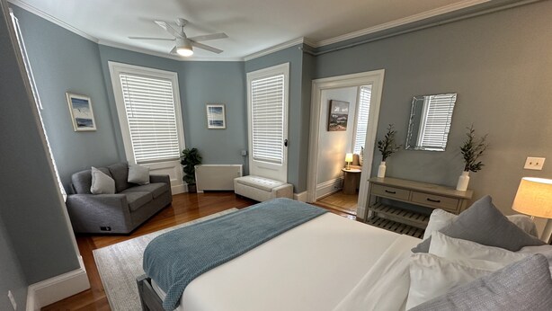 A bedroom with a bed, a sofa, a desk, and a chair. - Spacious Suite 1 Bed/ 1 Bath/ Pullouts Sofas - Unit 5 1 Bedroom Apts (Newport)