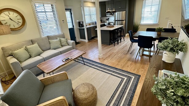 A modern living room with a sofa, a coffee table, and a dining area with a table and chairs. - Downtown Newport 2br Apartment W/ Parking & Deck - Unit 4 2 Bedroom Apts (Newport)