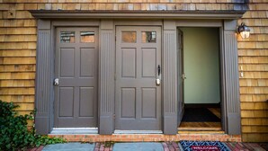 A building with two grey double doors and a small entrance. - Unique 2 Bed 1 Bath Apartment Off Broadway #3 2 Bedroom Apts (Newport)