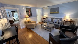 A living room with a sofa, armchairs, a coffee table, and a dining table. - Large & Unique Two Bedroom Apartment Downtown #17 2 Apts (Newport)