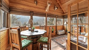 A wooden interior with a round dining table, chairs, and a sofa. - Sbl51 The Hunt Cabin At Stonebridge 2 Bedroom Cabin (Branson West)
