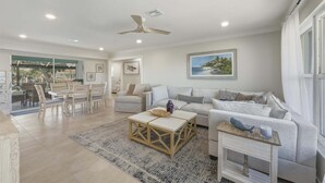 A spacious living room with a sofa, coffee table, and a dining area with chairs. - Jun931 3 Bedroom Home (Punta Gorda)
