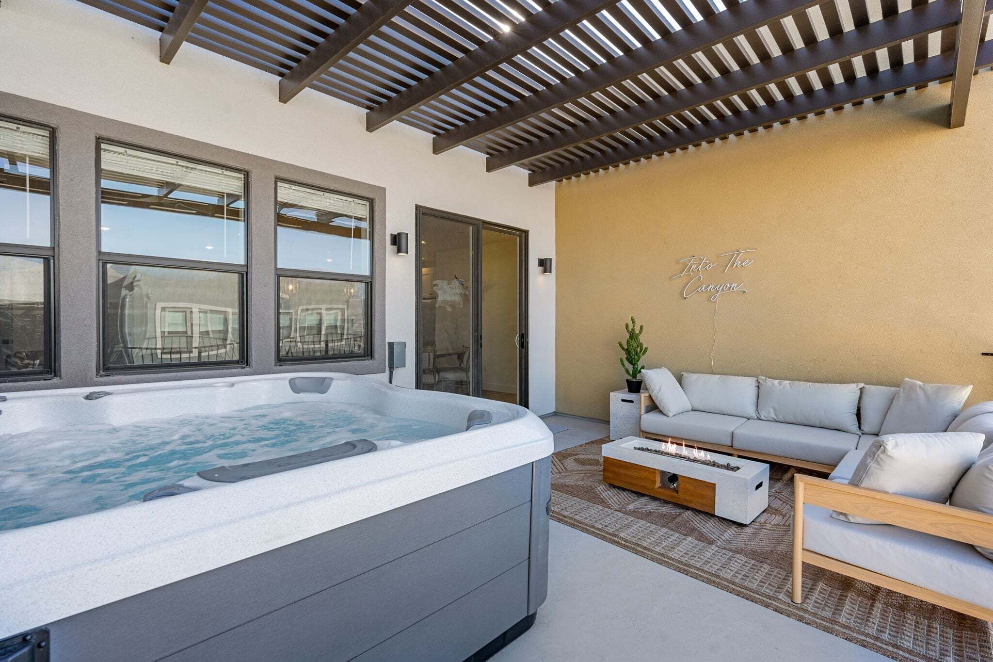 A modern living room with a hot tub, a sofa set, and large windows.