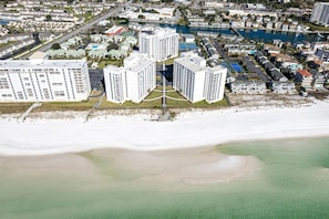 An aerial view of a coastal residential area with high-rise buildings, a beach, and a marina. - Shoreline Towers 1045 2 Bedroom Condo (Destin)