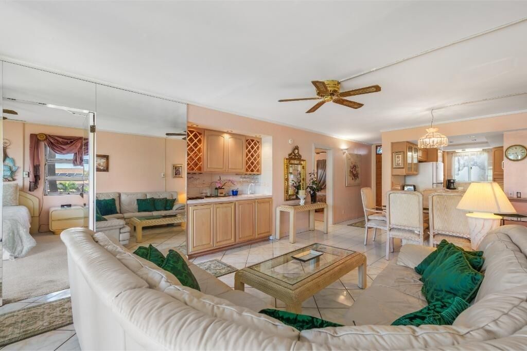 A spacious living area with a sofa, coffee table, and a dining area with chairs and a table.