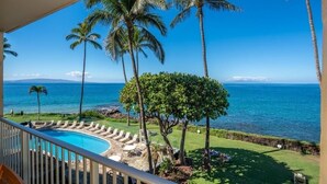 A poolside view with a clear ocean view, palm trees, and a well-maintained lawn. - Royal Mauian, #314 2 Bedroom Condo (Kihei)