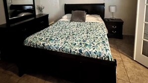 A bedroom with a bed, a ceiling fan, a nightstand, a dresser, and wall art. - Wonderful 3-bedroom house with Pool and garage Las Vegas (North Las Vegas)