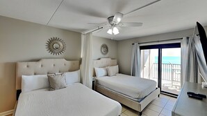A hotel room with two beds, a ceiling fan, and a balcony with a view. - Ocean Breeze West #504 | Gulf-Front Balcony + Resort Amenities (Perdido Key)