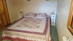 Un dormitorio con una cama, dos mesitas de noche y un armario de madera.