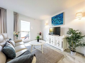 A modern living room with a sofa, a coffee table, a TV, and a potted plant. - 97- Lovely Townhouse With Stunning Views & Pool in Marbella! (Artola)