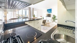 Una cucina moderna con piano cottura integrato, lavello e zona pranzo con tavolo e sedie.