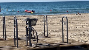 A beach with a wooden boardwalk, metal railings, and a bicycle with a basket. - Charming family winegrower's house in the center of Marseillan, sleeps 12 (Marseillan)