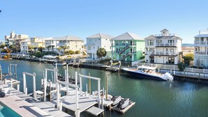 A marina with docked boats, a clear sky, and colorful buildings along the waterfront.
