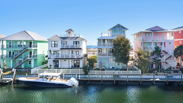 A row of colorful houses by a waterfront, with a boat docked in the foreground.