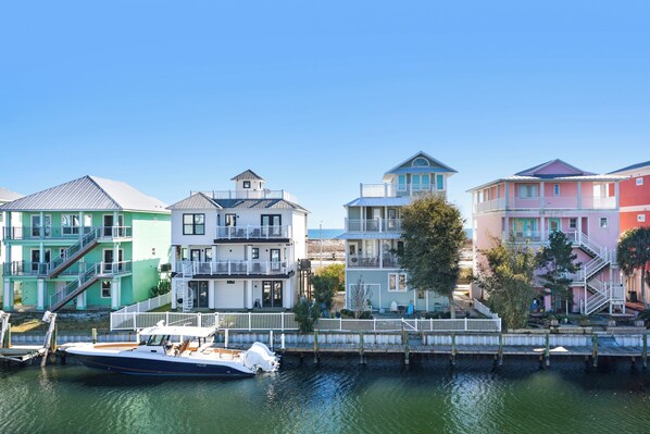 A row of colorful houses by a waterfront, with a boat docked in the foreground.