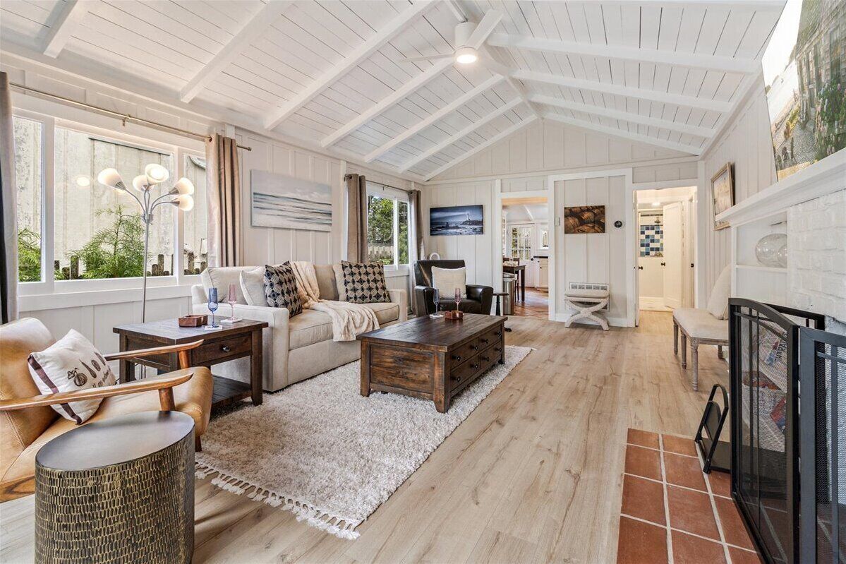 A spacious living room with a high ceiling, a fireplace, and a television.