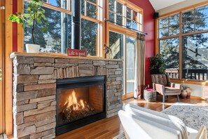 A cozy living room with a stone fireplace, large windows, and a comfortable seating area. - Secluded Alpine Getaway Minutes from Breckenridge (Blue River)