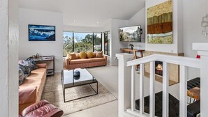 A modern living room with a sofa, coffee table, and artwork. - 4062 Pretty Perfect Penthouse - Carmel-by-the-Sea (Carmel)