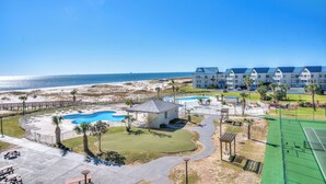 Ein Resort mit Pool, Tennisplatz und Blick auf den Strand.