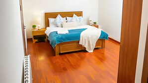Ein Schlafzimmer mit einem hölzernen Bett, weißen Wänden und einem Holzboden.