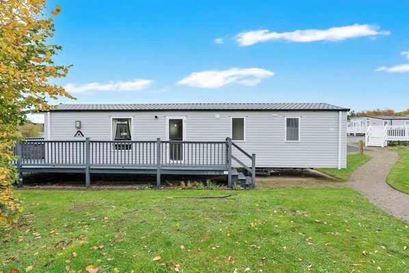 A single-story mobile home with a front porch and a small attached garage.