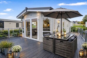 A covered outdoor seating area with a table, chairs, and an umbrella.