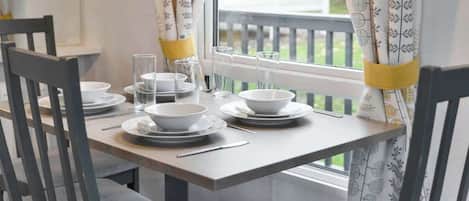 A dining table set with plates, bowls, glasses, and cutlery.