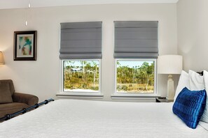 A hotel room with a large bed, two windows with blinds, a brown sofa, a lamp, and a framed picture on the wall. - 🐠Easy Beach Access | Game Room | Pet Friendly | Fish-n-Ships⚓ (Windmark Beach)