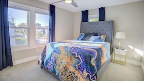 A bedroom with a large bed, a ceiling fan, a nightstand, and a window with curtains. - Cozy Fountain Square Retreat Just Steps from Downtown Indianapolis (Indianapolis)