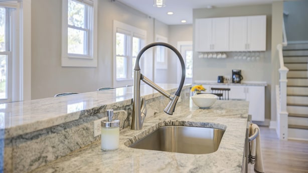 A kitchen with a granite countertop, stainless steel sink, and white cabinets. - Cozy Fountain Square Retreat Just Steps from Downtown Indianapolis (Indianapolis)