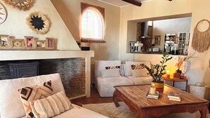 Ein gemütliches Wohnzimmer mit einem großen Bett, einem Holztisch und einem Kamin.