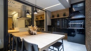 Cuina moderna amb una illa gran, cadires negres i il·luminació penjant.