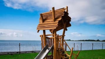 Une aire de jeux avec un toboggan et des structures d’escalade.