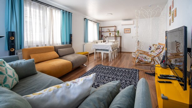 A modern living room with a sofa, dining table, and a TV stand. - Unique 4-Level Home in the Heart of Beşiktaş (Istanbul)