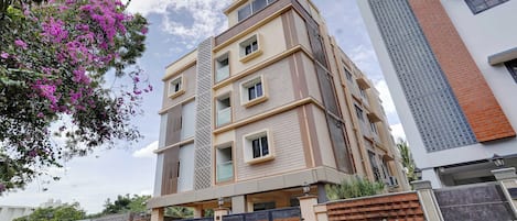 A multi-story residential building with a modern design, featuring balconies and large windows.