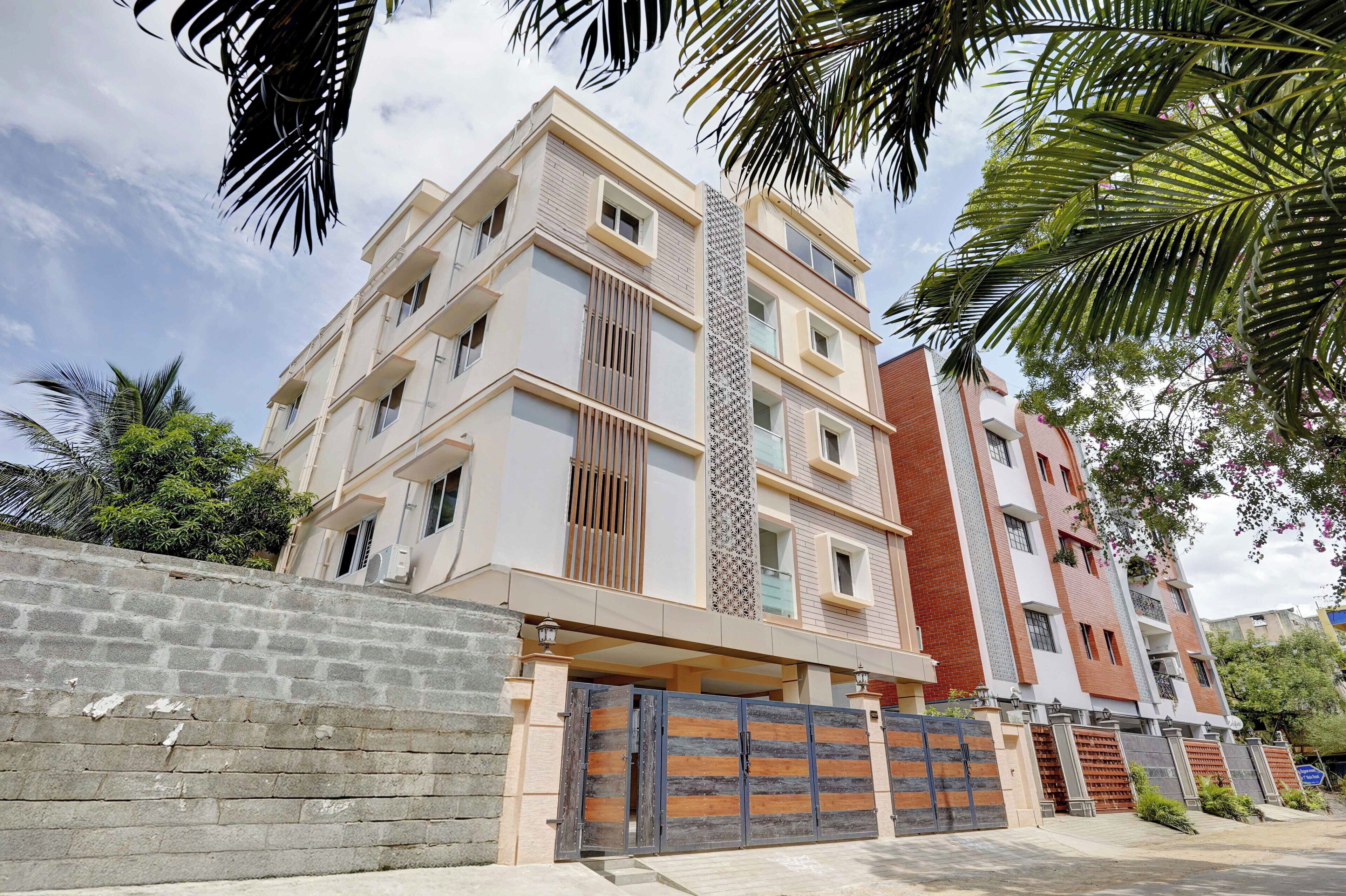 A multi-story residential building with a modern design, featuring balconies and large windows.