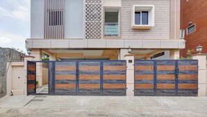 A modern two-story house with a garage, a decorative wall, and a gated entrance. - Ecostay Valasaravakkam (Chennai)