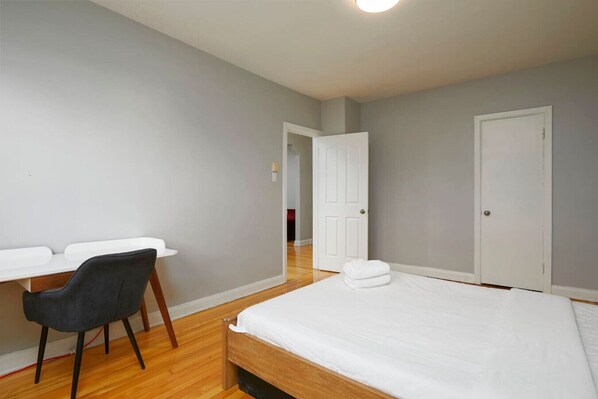 Une chambre à coucher avec un lit, un bureau et une chaise.