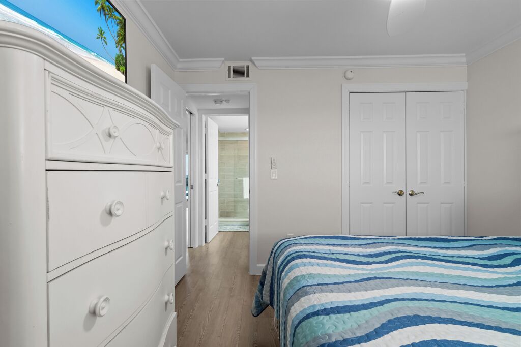 Un dormitorio con una cama, un aparador y un armario.