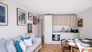 A modern apartment with a living room, dining area, and kitchen. - Queens Park Apt w/ mini garden near Notting Hill (London)
