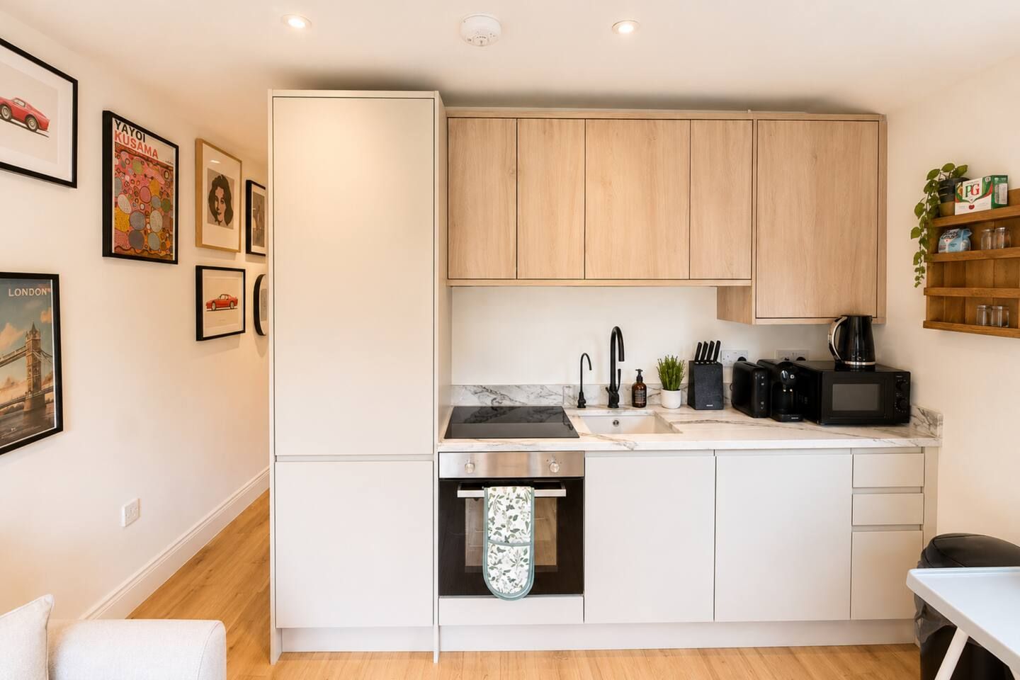 A compact kitchen with wooden cabinets, a built-in oven, and a sink.