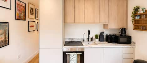 A compact kitchen with wooden cabinets, a built-in oven, and a sink.