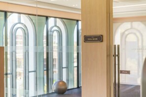 Entrada d'hotel amb un rètol per a la sala de ioga, una porta corredissa i una vista per les portes de vidre.