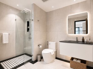 A modern bathroom with a glass-enclosed shower, a toilet, and a vanity with a mirror. - NEW Suite 2BR The Title IBG Legendary BangTao (Choeng Thale)