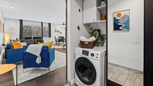 Un apartamento moderno con sala de estar, comedor y lavadora y secadora integradas.