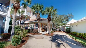 A residential area with multiple houses, palm trees, and a paved walkway. - Mango Tango - Dog Friendly 5 BR home in gated community close to beach (Miramar Beach)