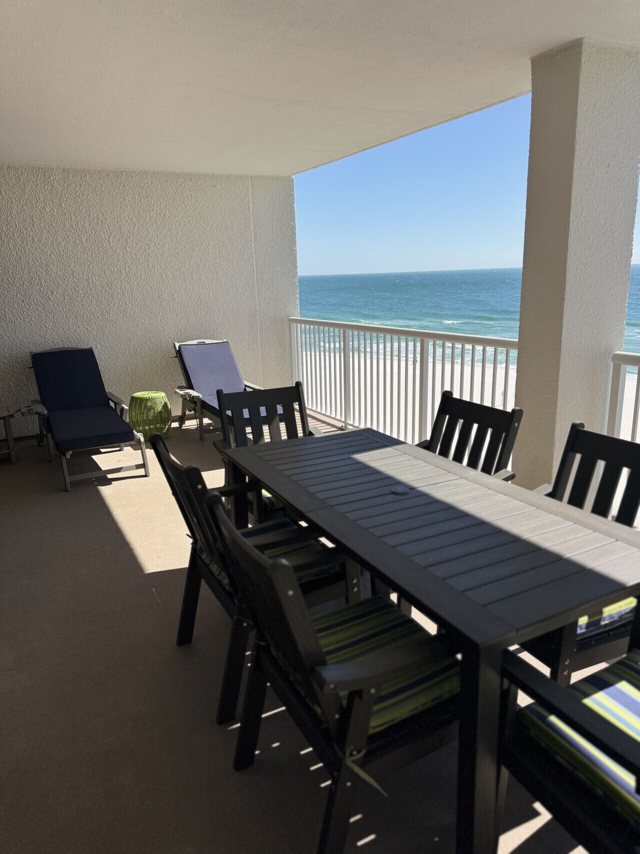 Un balcone con tavolo e sedie, vista sull'oceano.
